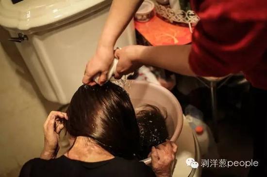 周巖在母親的幫助下洗頭。新京報記者彭子洋攝