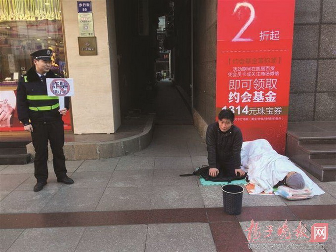 城管在假乞丐旁舉牌 這個“乞丐”很有故事曾去過新加坡乞討